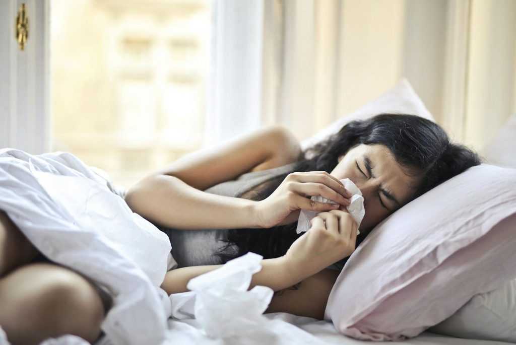 mujer tumbada en cama con problema respiratorio