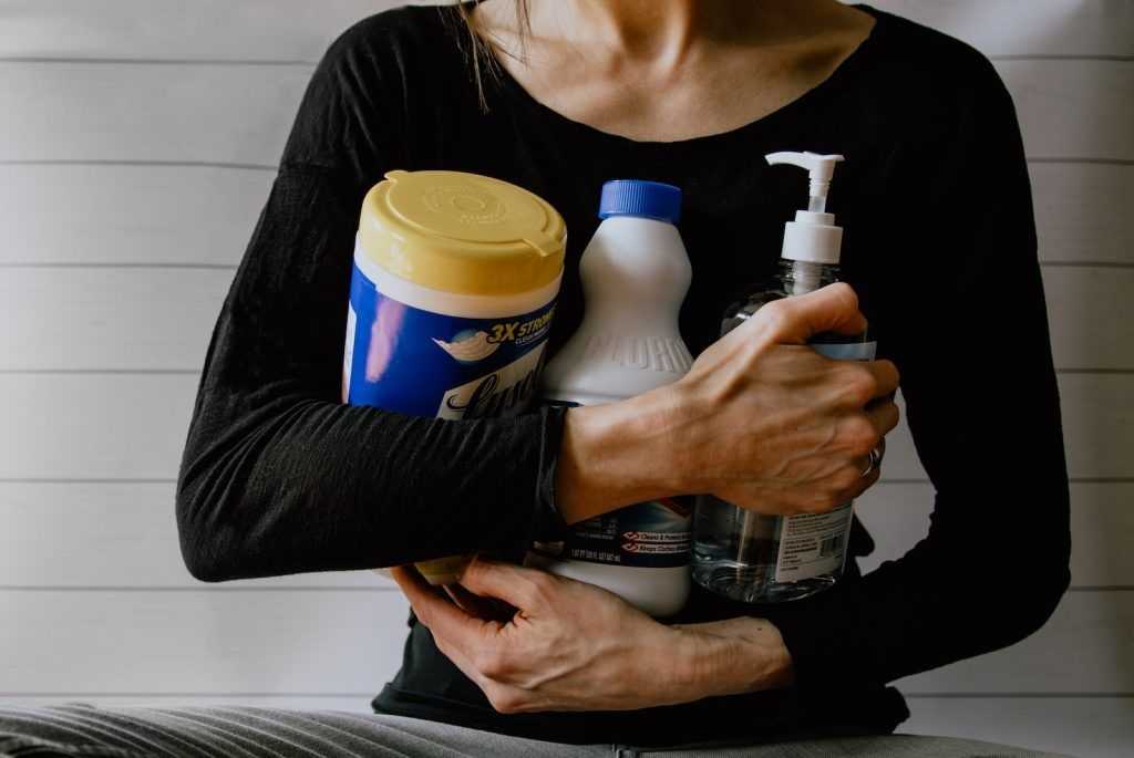 mujer sujetando productos de limpieza