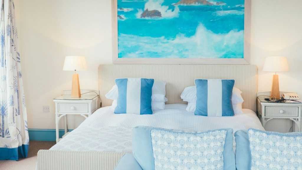 white and blue pillows beside brown table lamp